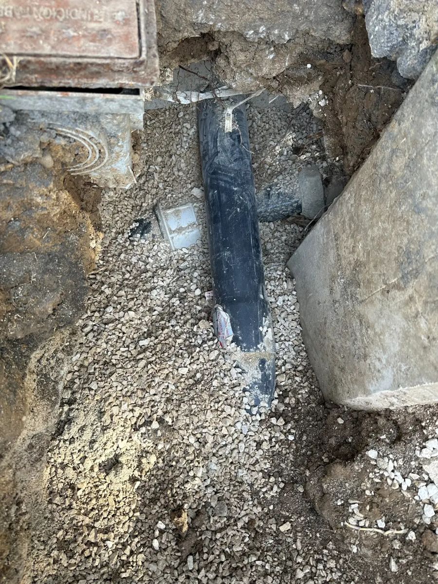 Tubería negra de polietileno descubierta sobre lecho de grava